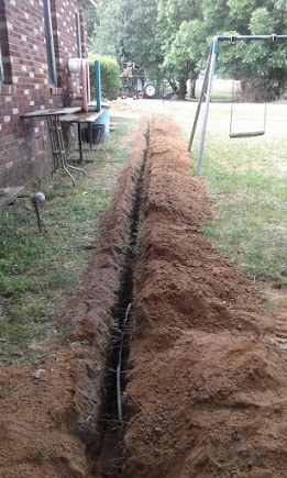 Freshly excavated sewer line trench across a Apex backyard